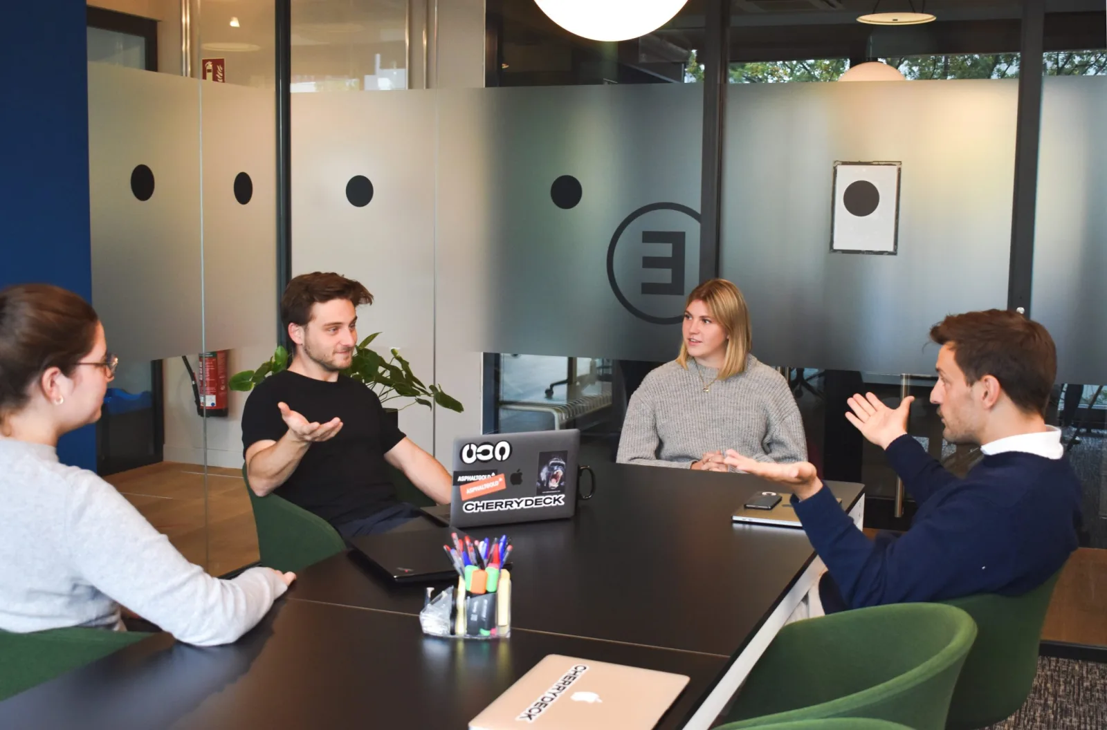 Four colleagues talking together in an informal meeting room